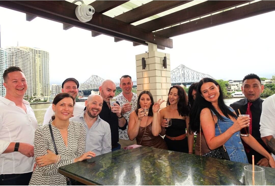 A large group celebrating together at a riverside bar