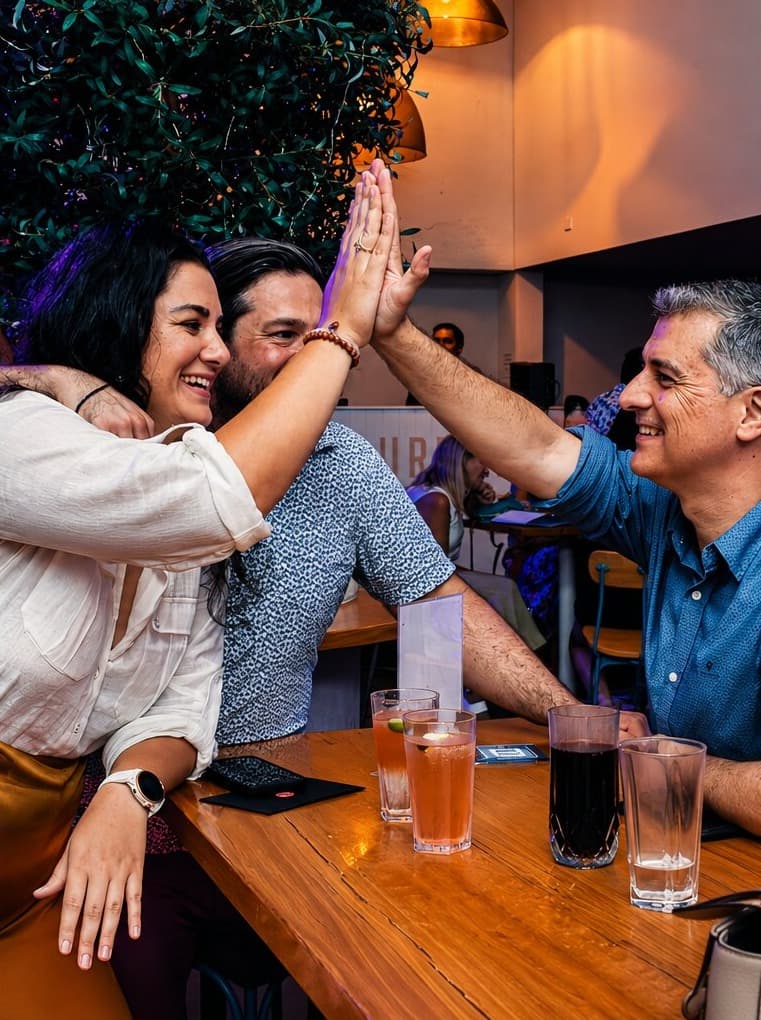 Three agents high-fiving over drinks after solving a clue