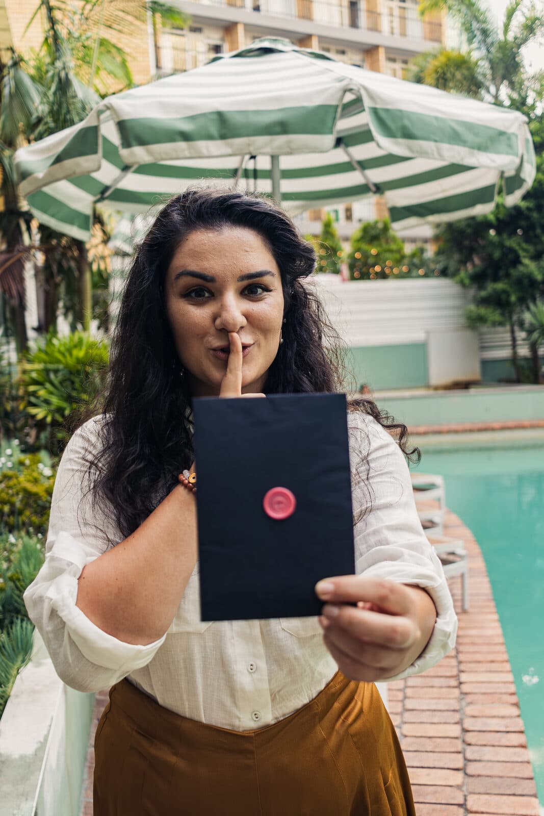 An agent revealing a movie-themed clue card by the river